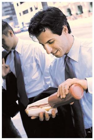 According to the National Cancer Institute, men are approximately 1.5 times as likely as women to develop colorectal cancer or heart disease. Both diseases may be prevented by eating well. The convenience and economic appeal of fast foods, such as hot dogs, can lead to poor dietary habits. [Royalty-Free/Corbis. Reproduced by permission.]